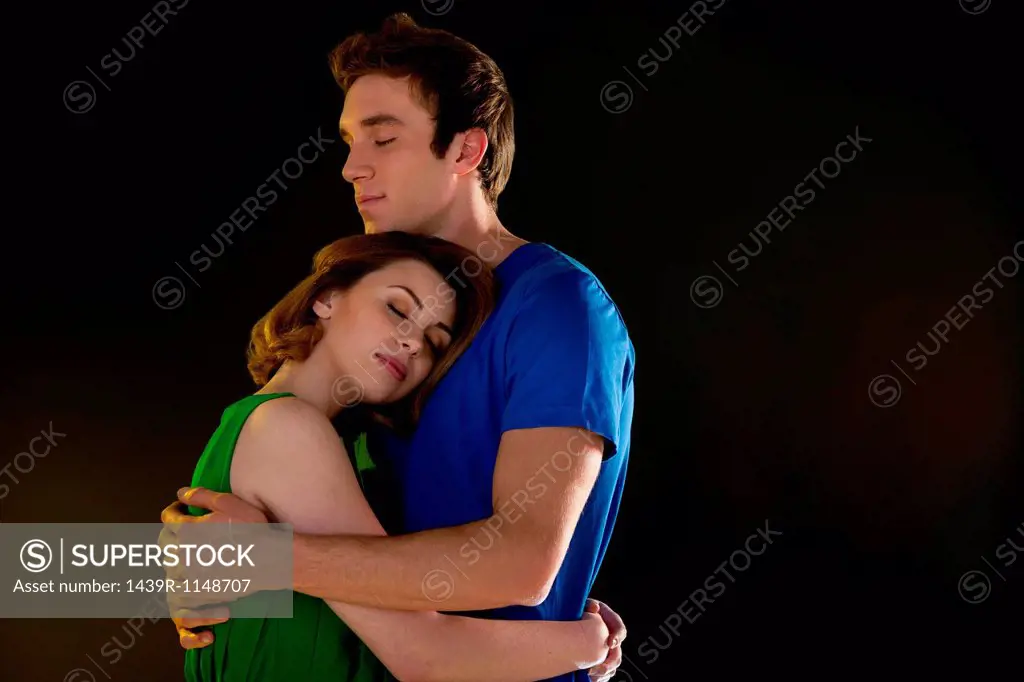 Young couple hugging with closed eyes