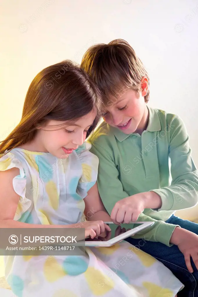 Girl and boy using digital tablet