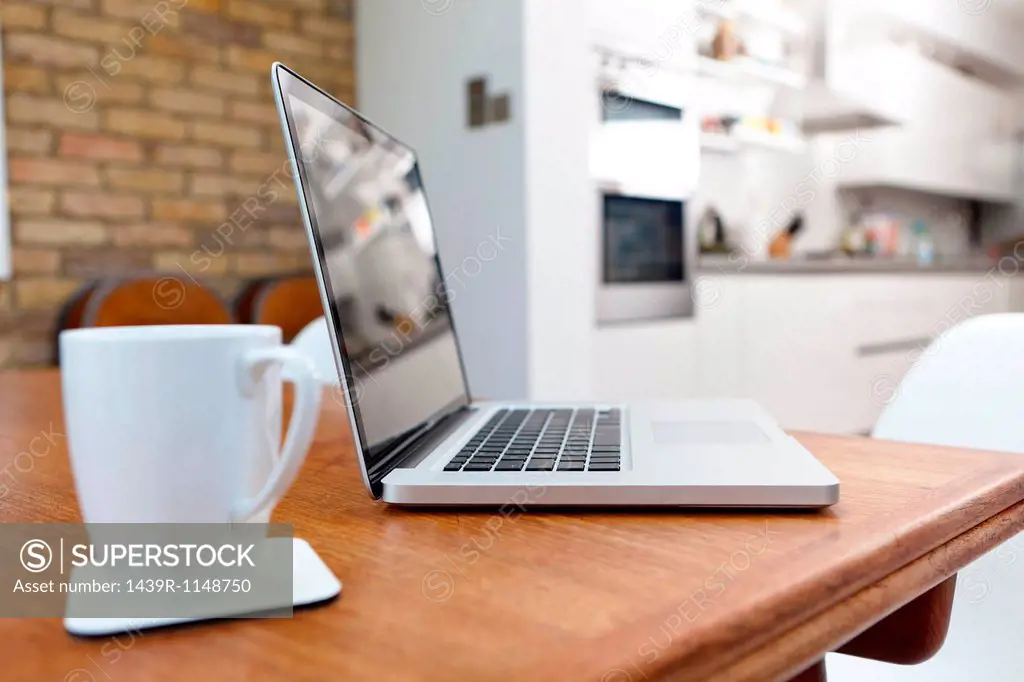 Laptop and mug on table