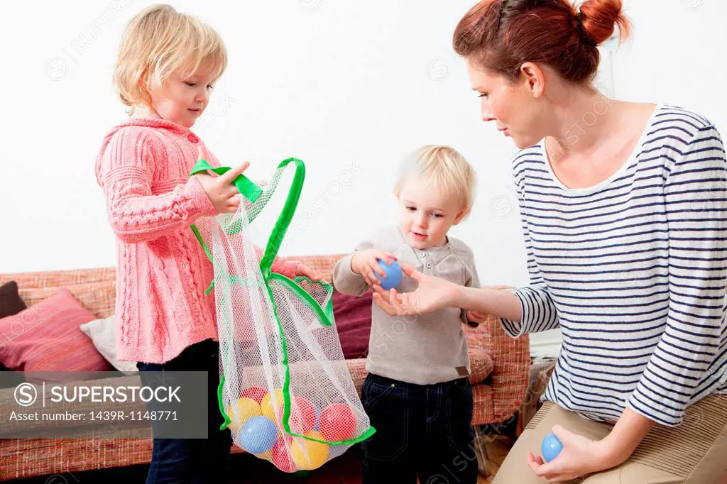 Mother and children playing with plastic balls