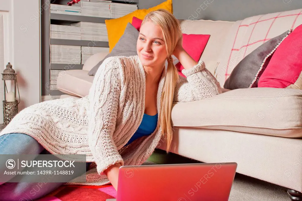 Woman using laptop daydreaming