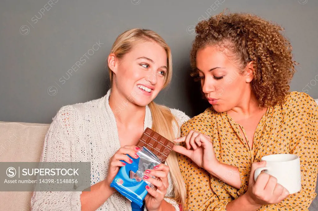 Woman offering friend chocolate