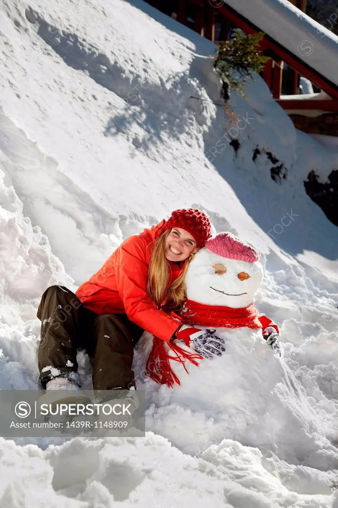 Woman with arms around snowman