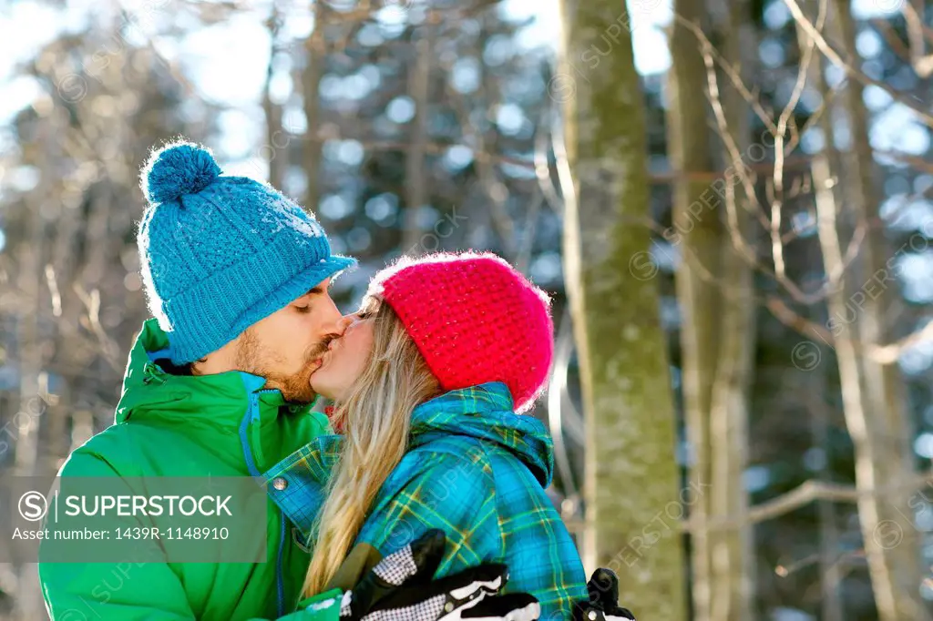 Couple wearing knit hats, kissing