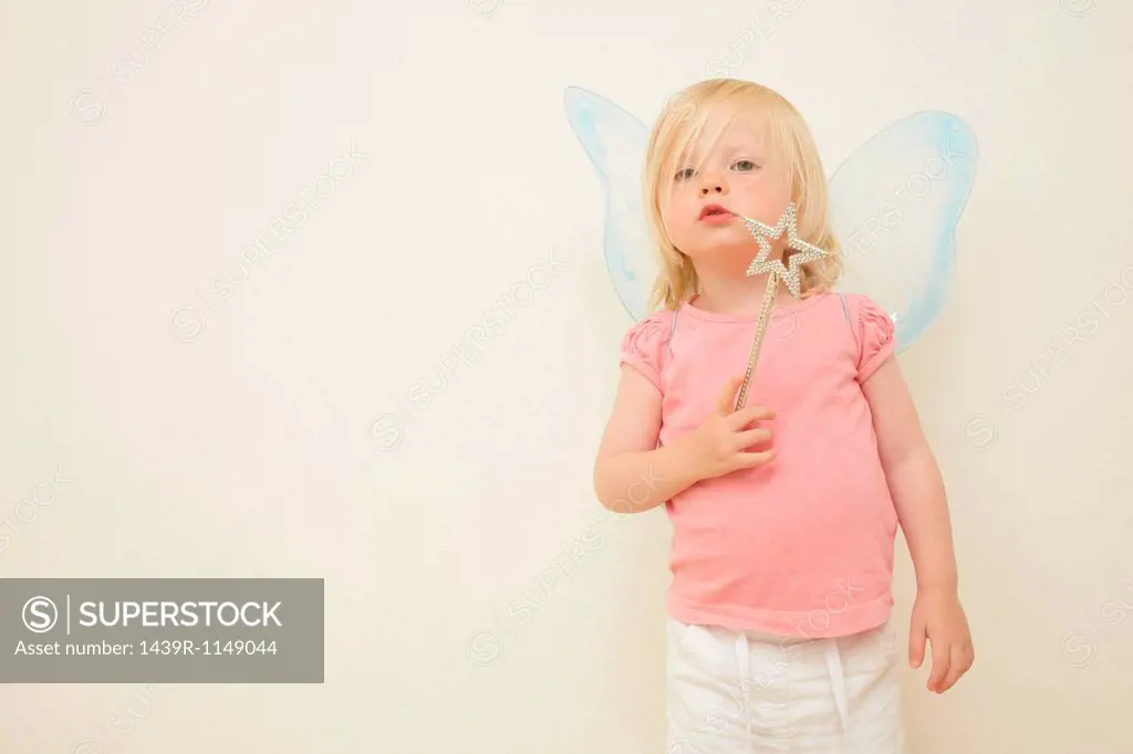 Toddler wearing wings, holding wand