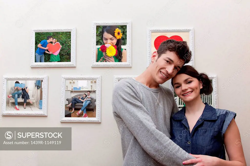 Young couple in front of wall of photographs
