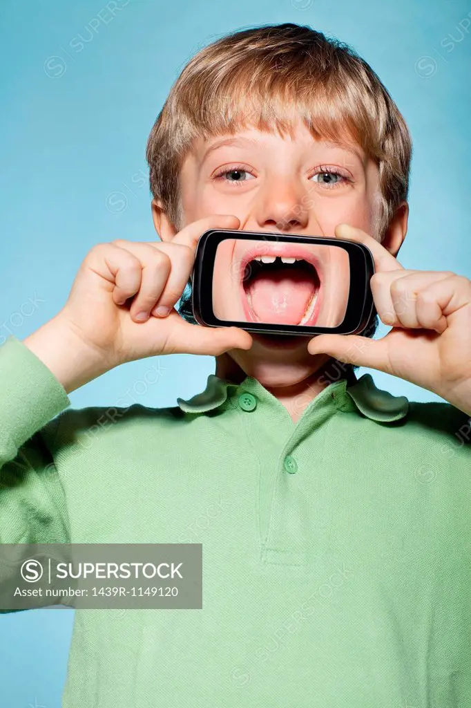 Boy holding smartphone over mouth