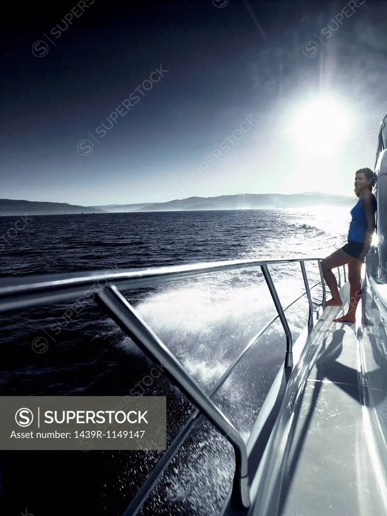 Woman standing alone on deck of yacht