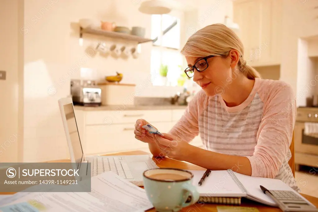 Woman with laptop holding credit card