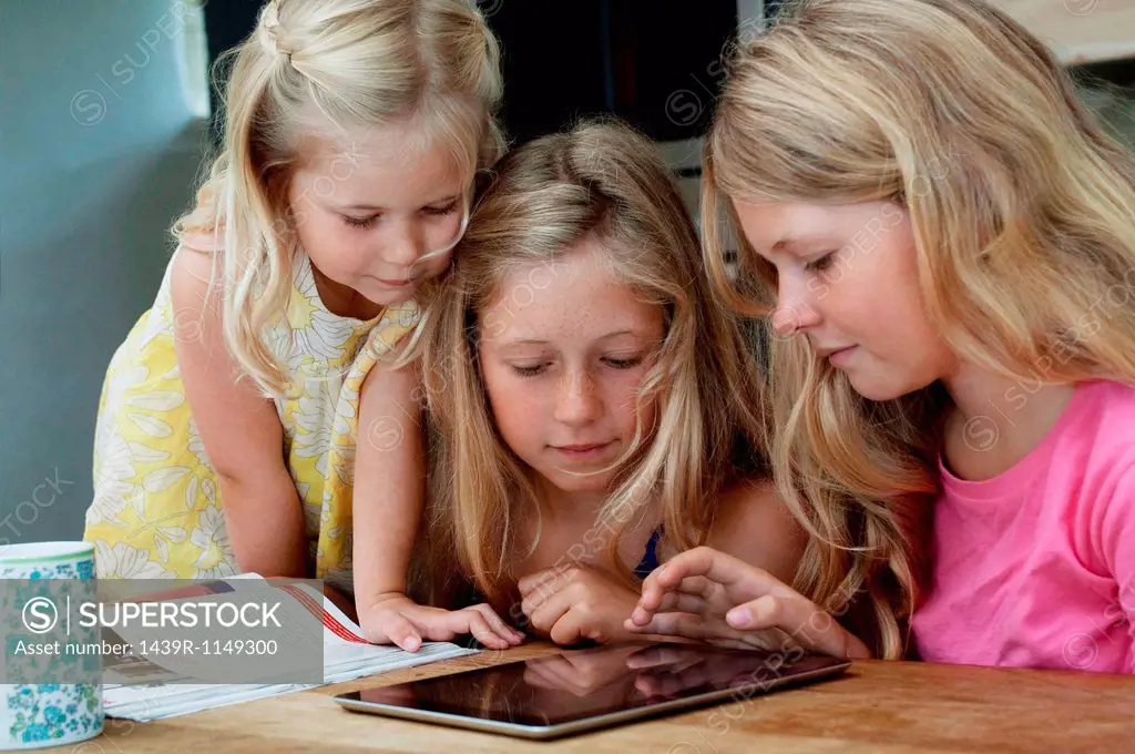 Three girls looking at digital tablet