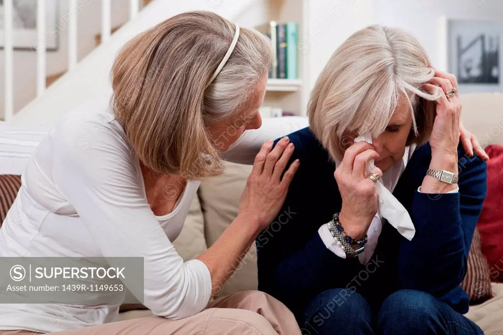Senior woman comforting crying friend