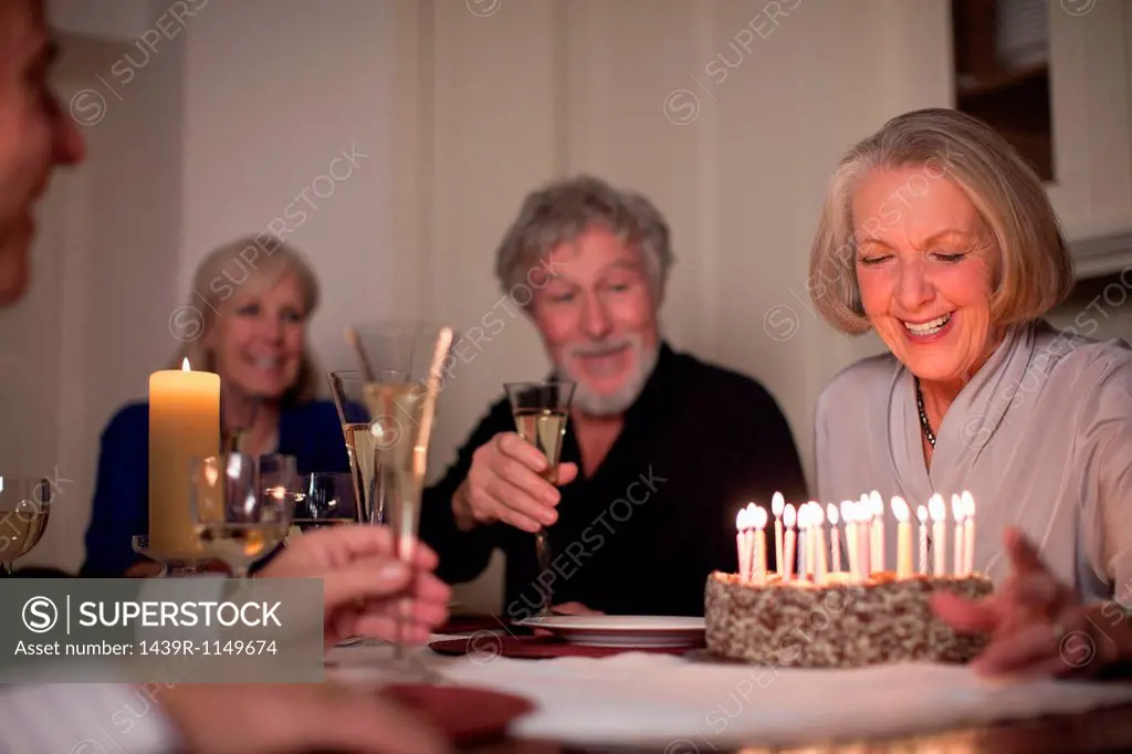 Senior woman and friends with birthday cake