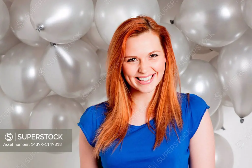 Happy young woman in front of balloons