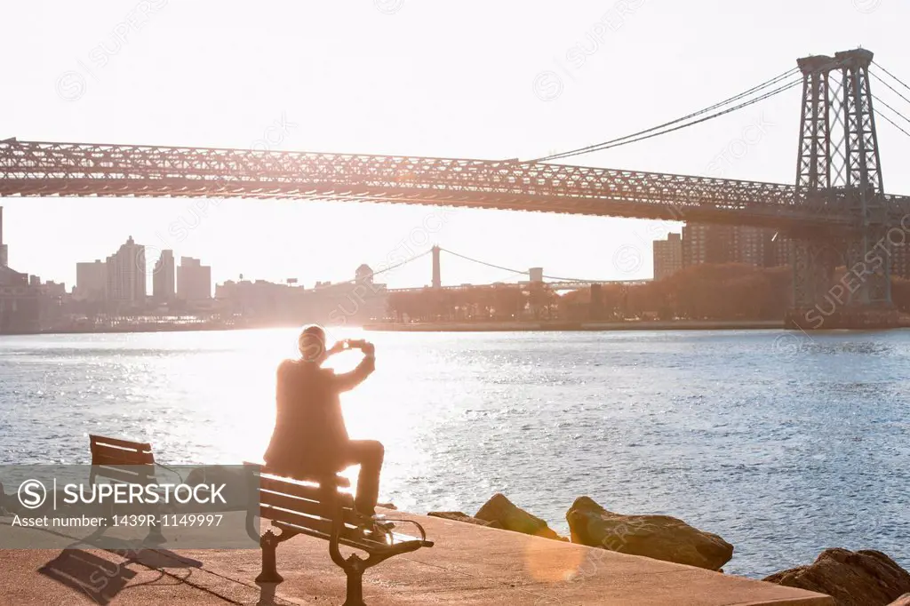 Man taking pictures of urban bridge