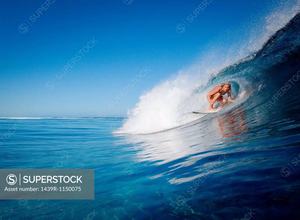 Woman surfing in crest of wave