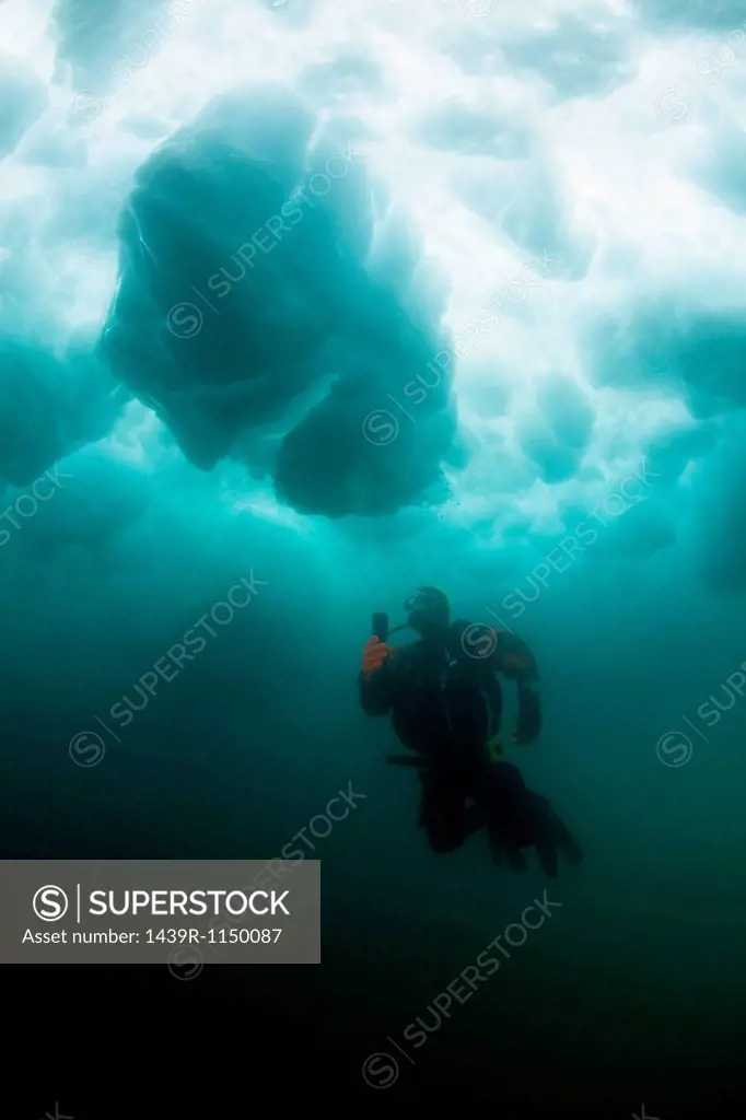 Man scuba diving under glacier