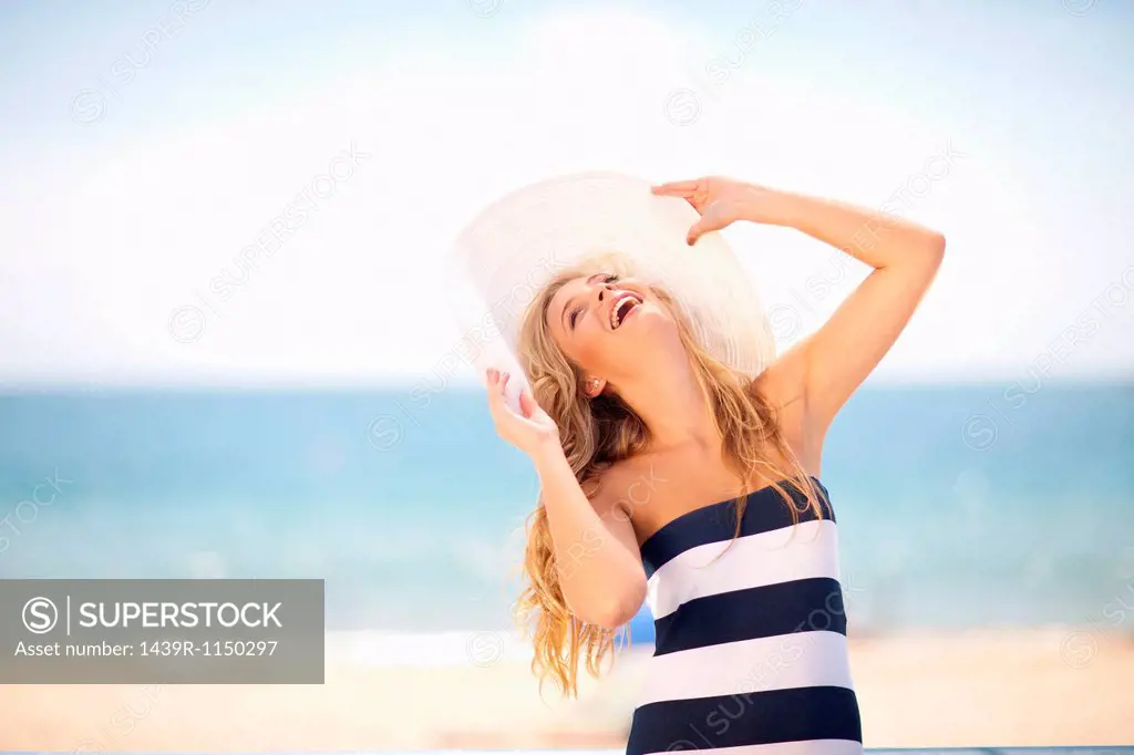 Woman wearing floppy hat on beach