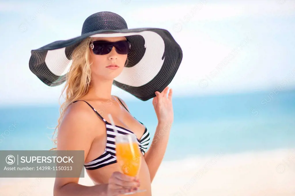 Woman in bikini and floppy hat on beach