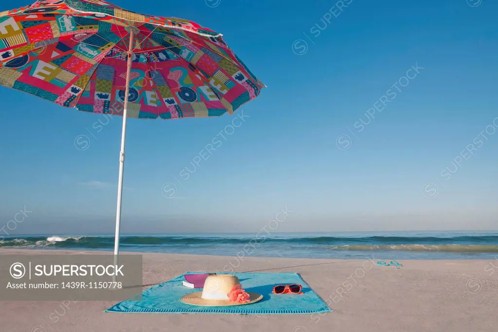 Blanket and towel on empty beach