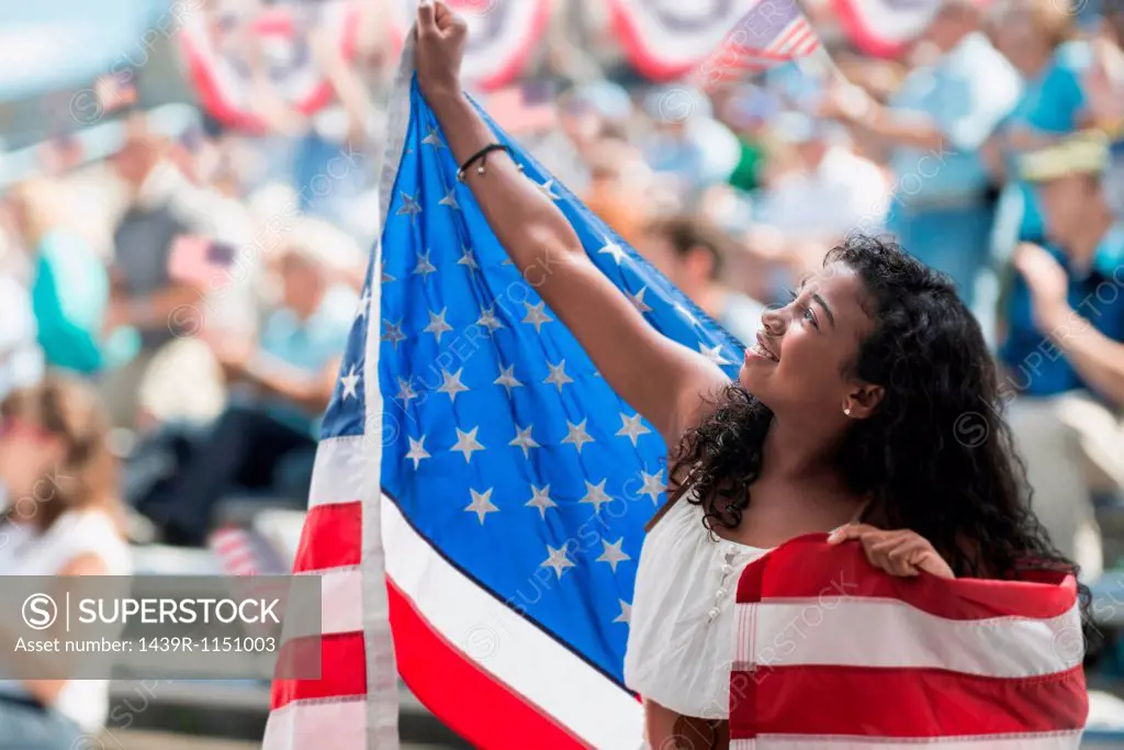 Girl at rally holding up american flag