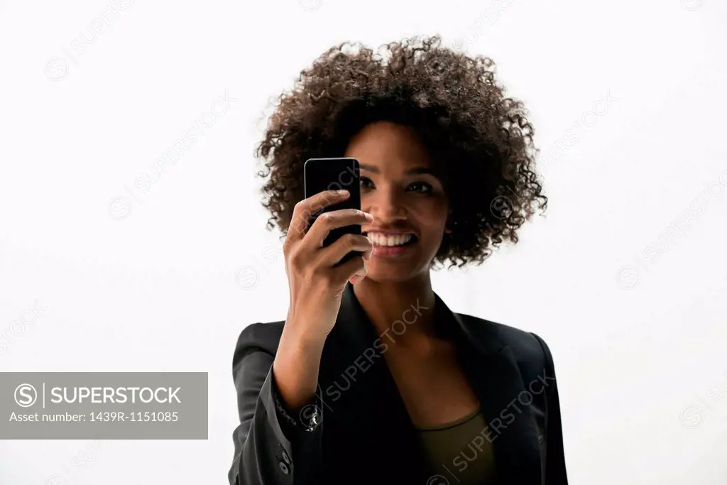 Businesswoman photographing self on cameraphone