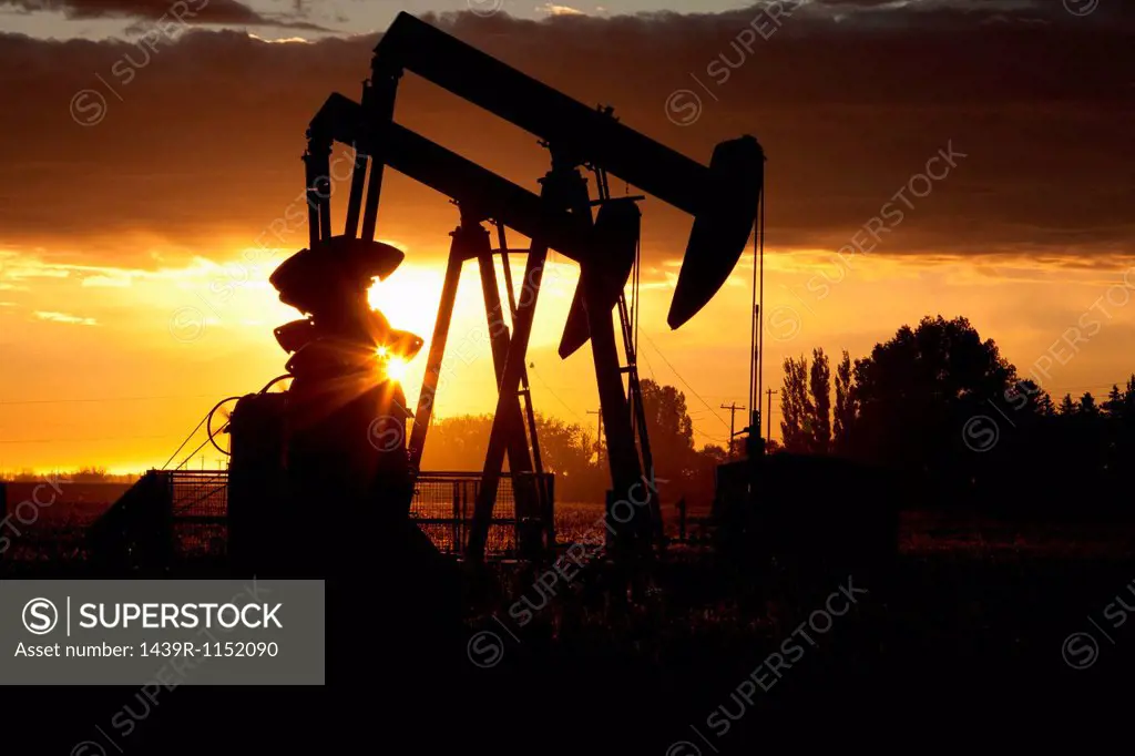 Silhouette of oil wells at sunset