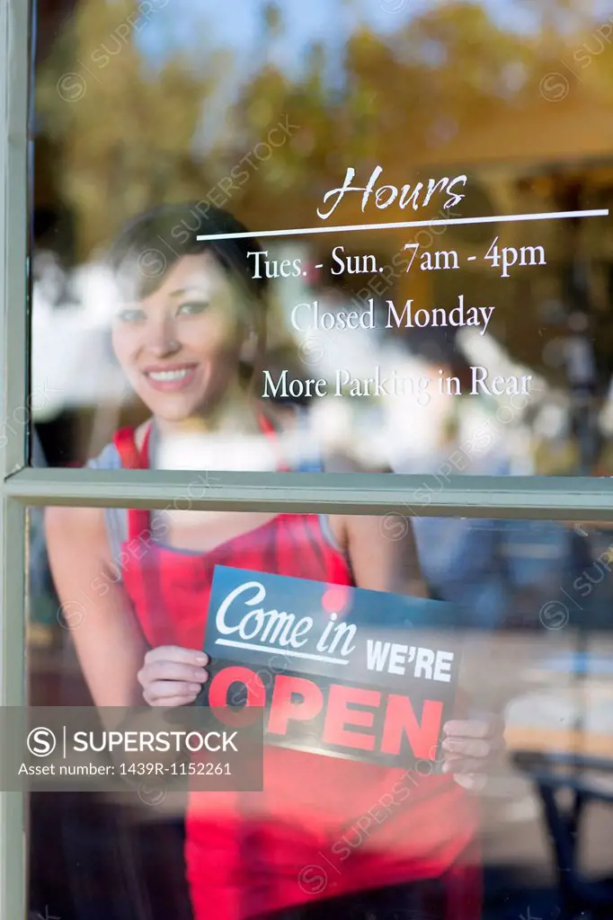 Waitress putting open sign in window