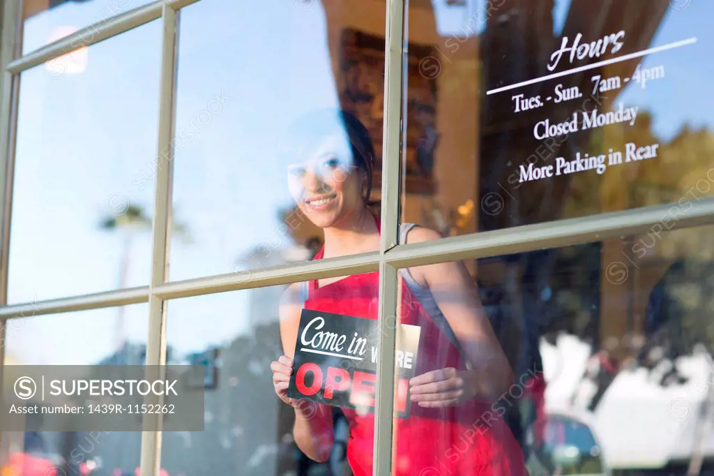 Waitress putting open sign in window