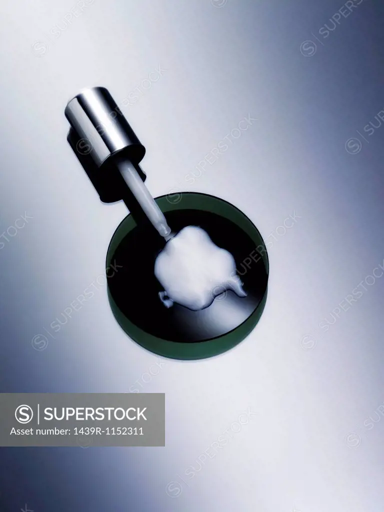 Dropper with lotion in petri dish