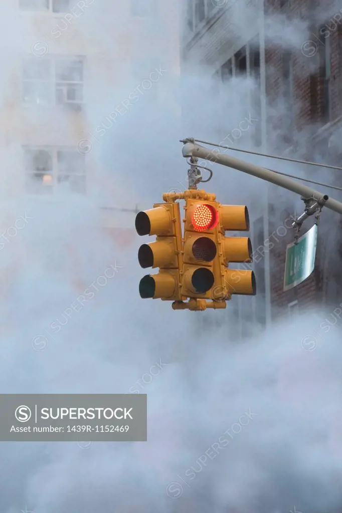 Traffic light on steamy city street