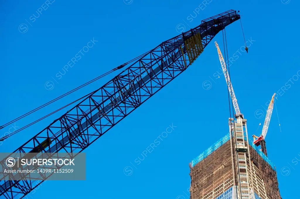 Low angle view of crane and skyscraper