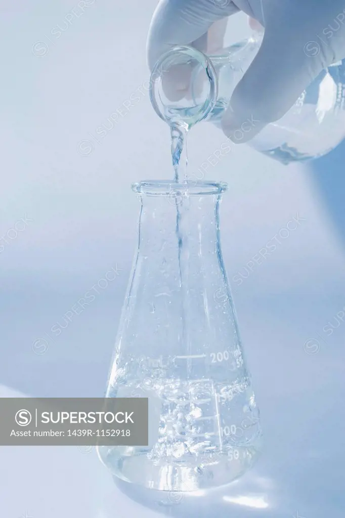 Scientist pouring liquid into beaker