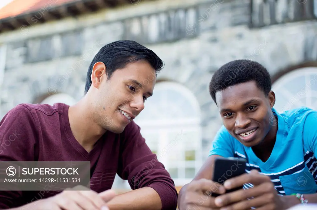 Two male friends using smartphone