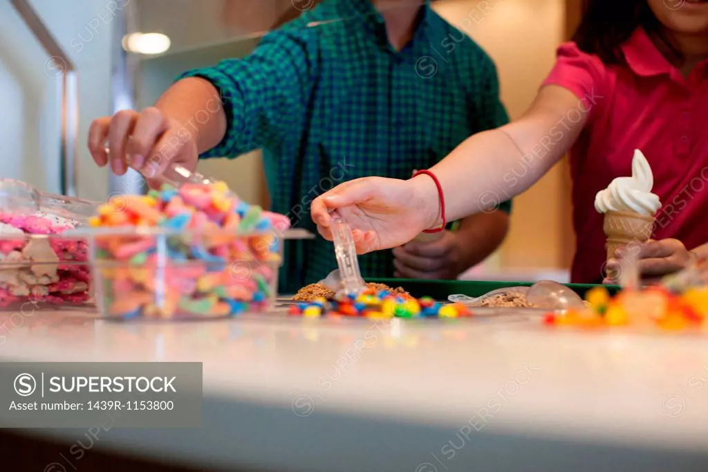 Children choosing toppings in store