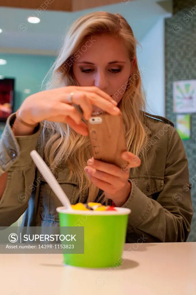 Woman taking picture of frozen yogurt