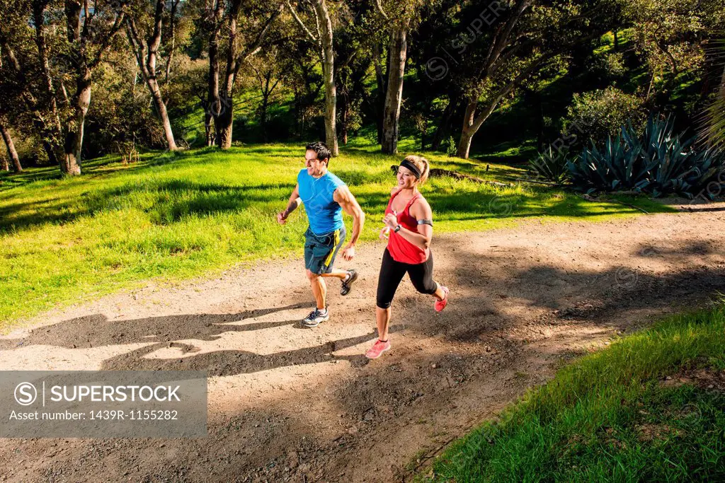 Two people jogging on forest path