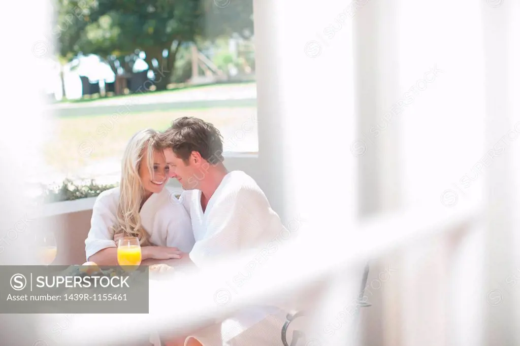 Young couple having breakfast on patio