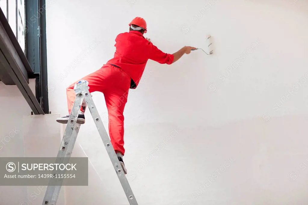 Decorator straddling step ladder