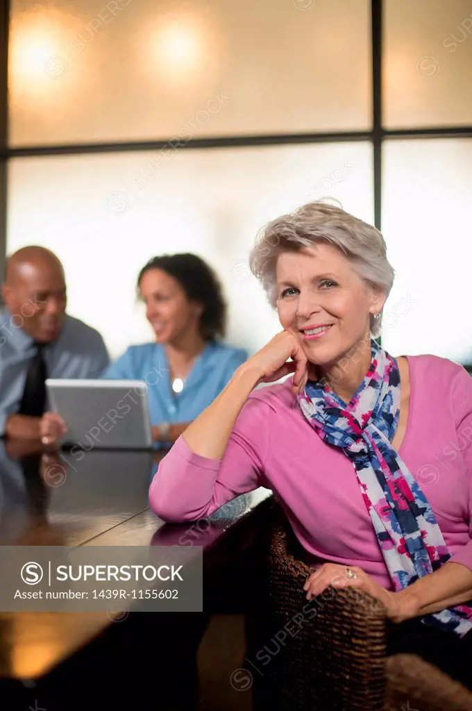 Mature woman with business colleagues in background