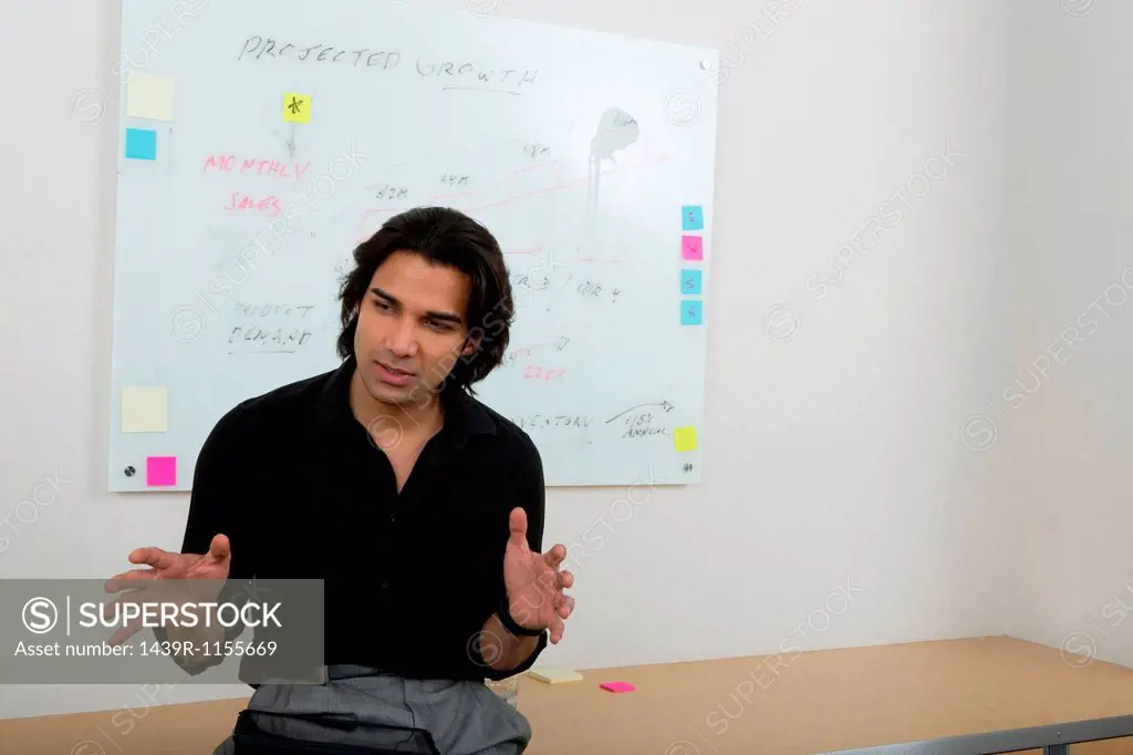 Young man with whiteboard in background