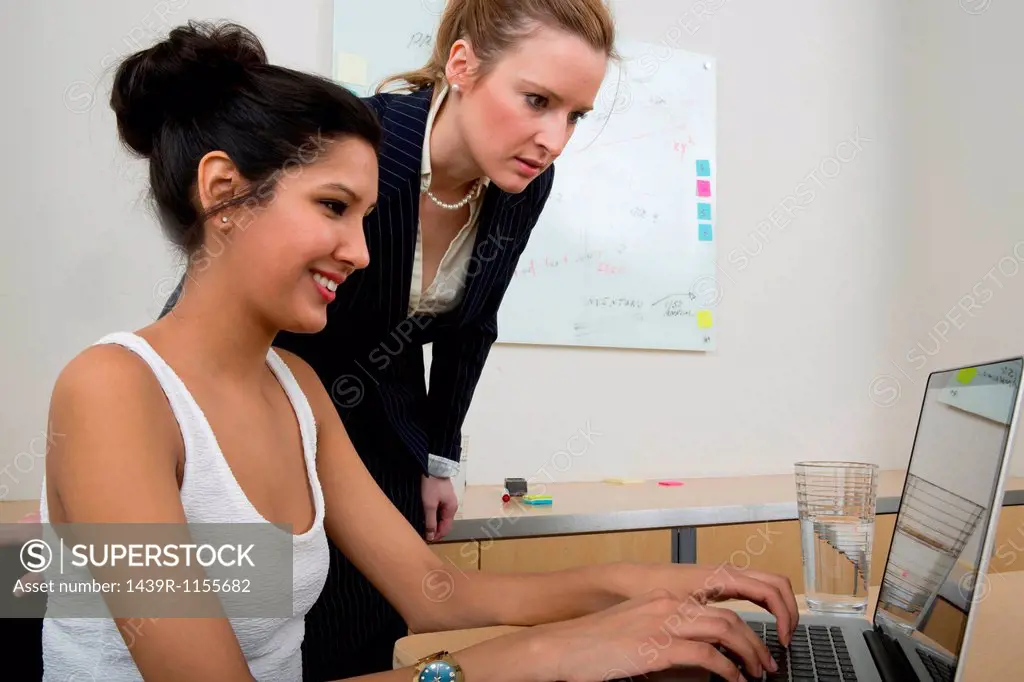 Young women at work using laptop