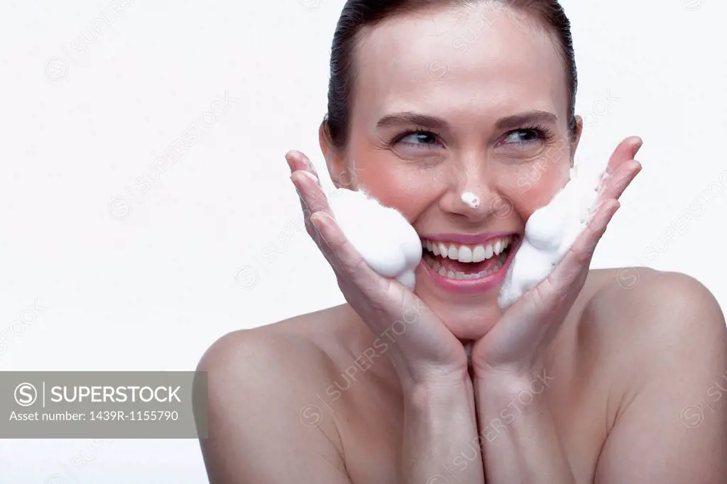 Young woman cleansing face