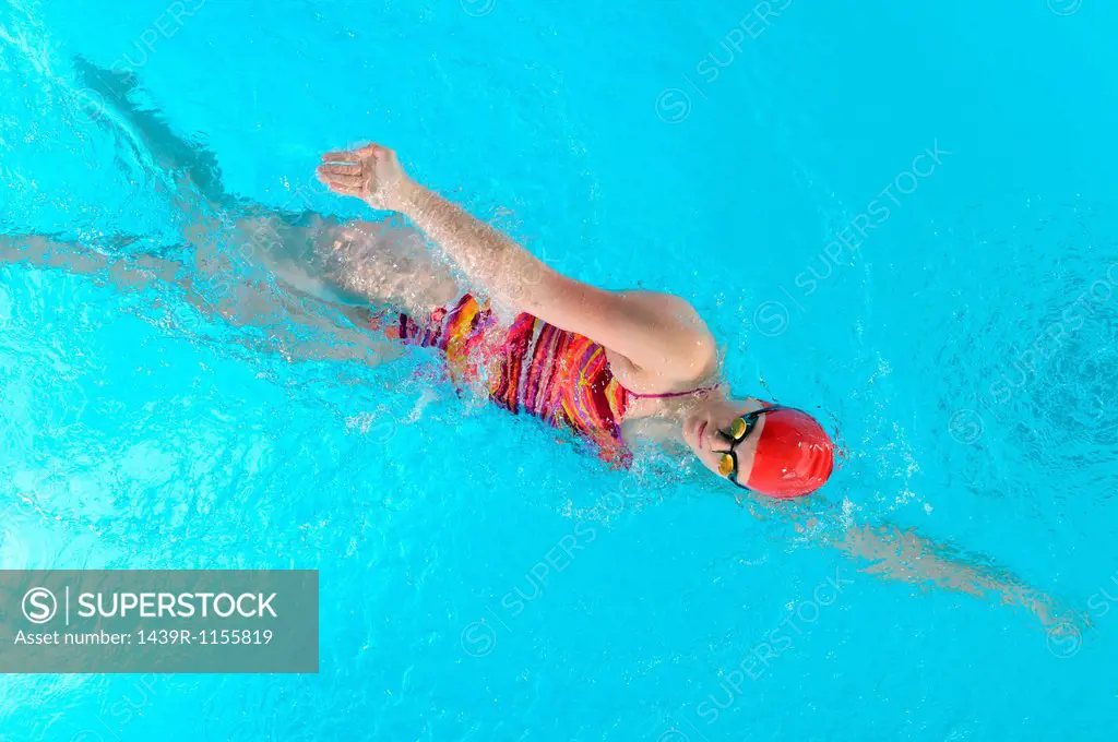 Teenage girl doing front crawl in swimming pool
