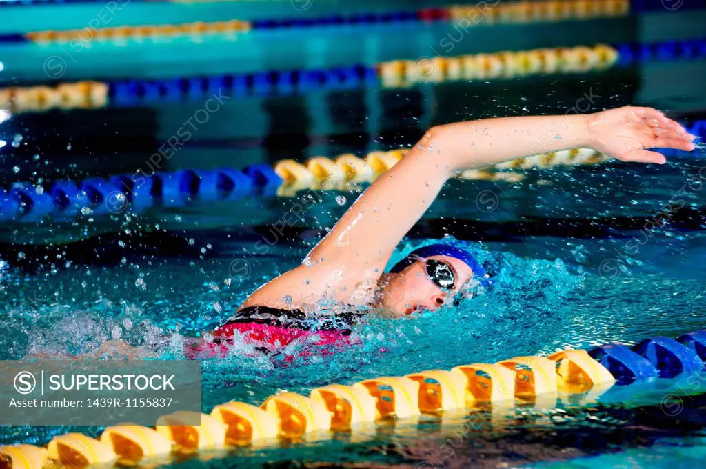 Young woman doing front crawl in swimming pool