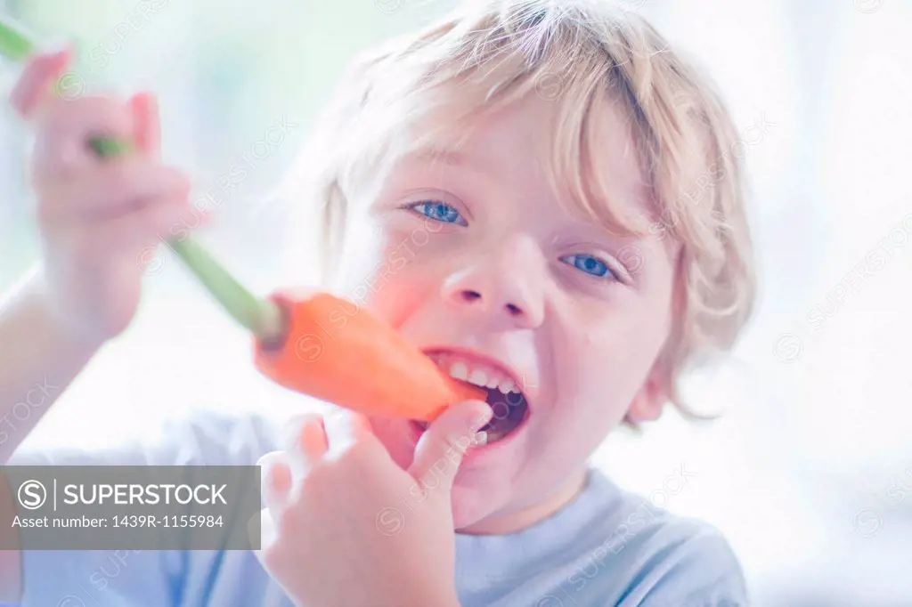 Boy eating carrot