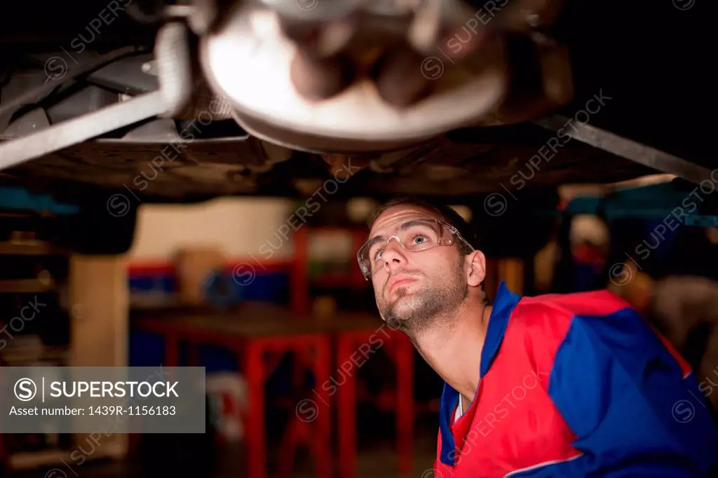 Car mechanic at work in service bay