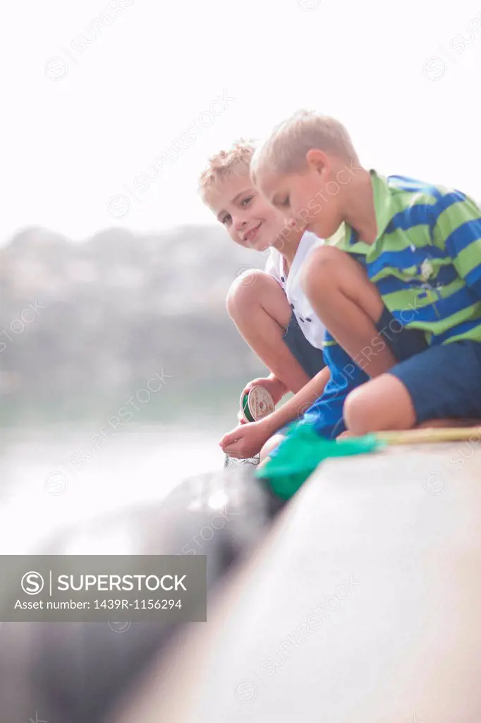 Close up of two young boys fishing on pier