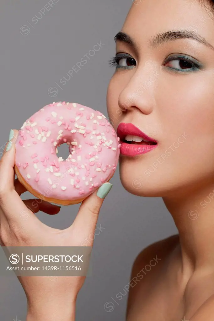 Young woman holding doughnut