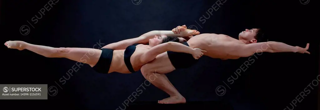 Mid adult dancers performing together in front of black background