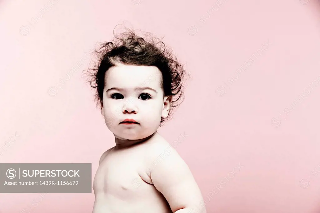 Portrait of baby girl against pink background